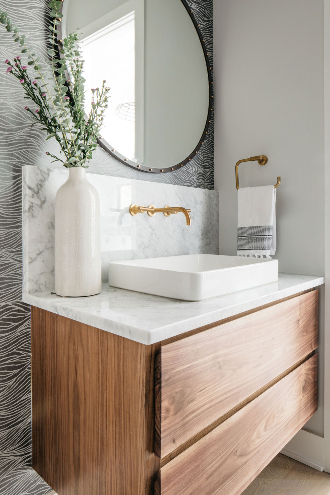 Idée de décoration pour un WC et toilettes vintage en bois brun avec un placard à porte plane, un mur gris, une vasque, un plan de toilette gris, meuble-lavabo suspendu et du papier peint.