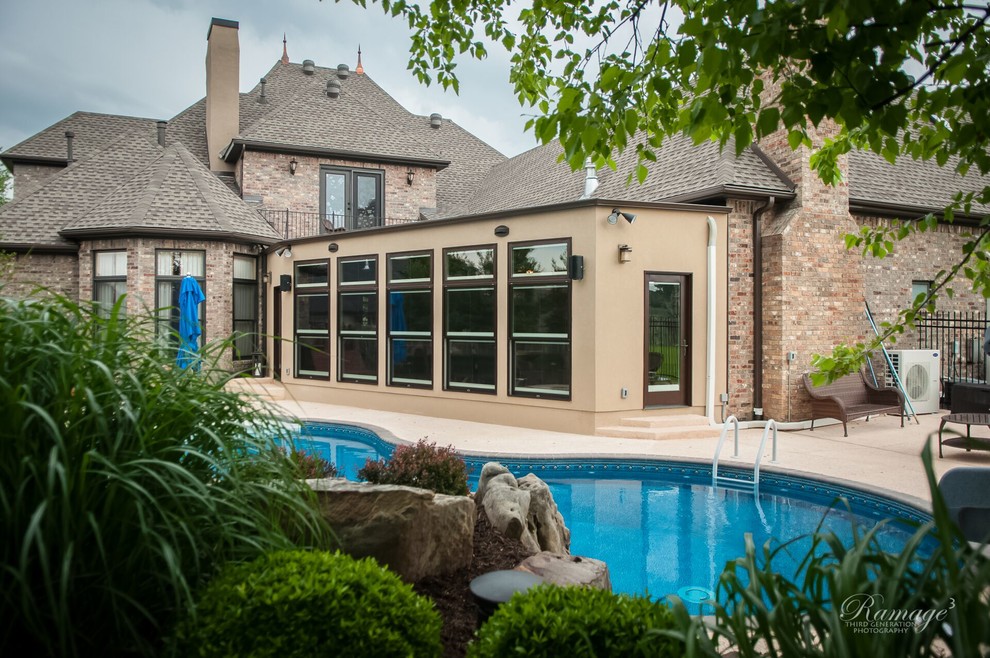 Inspiration for a mid-sized transitional backyard stamped concrete and custom-shaped lap water slide remodel