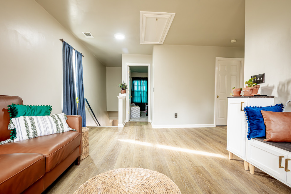 Стильный дизайн: изолированная гостиная комната среднего размера в морском стиле с белыми стенами, полом из винила, телевизором на стене и коричневым полом - последний тренд