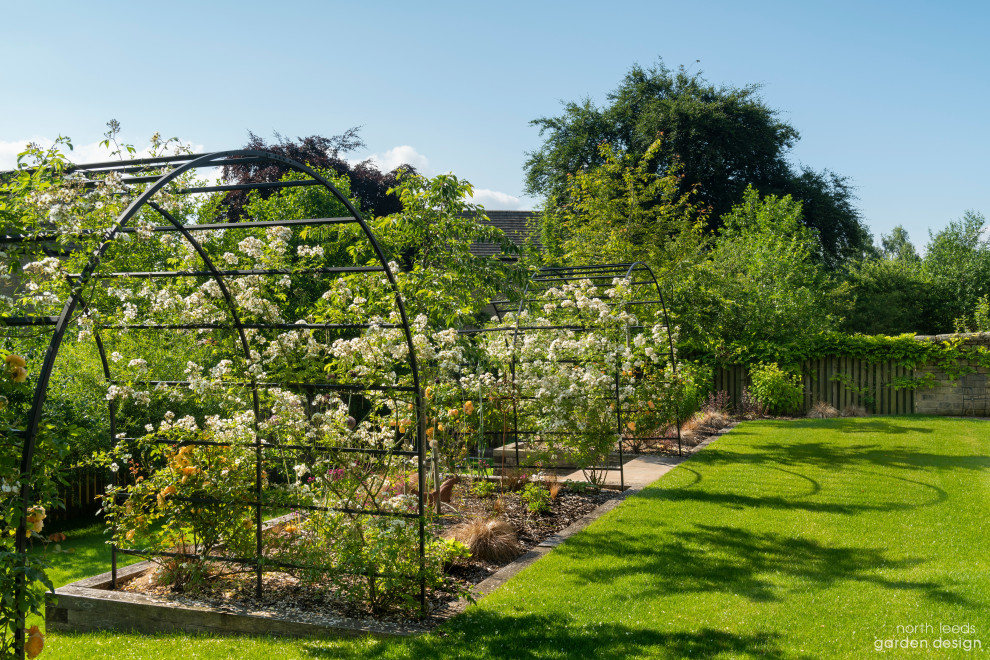 Foto di un grande giardino formale country esposto a mezz'ombra dietro casa
