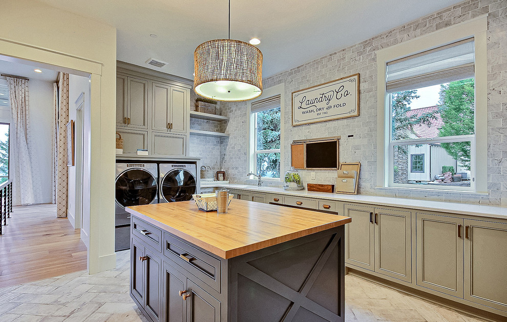 Expansive country u-shaped utility room in Portland with an undermount sink, shaker cabinets, green cabinets, quartz benchtops, grey walls, ceramic floors, a side-by-side washer and dryer, beige floor and brown benchtop.