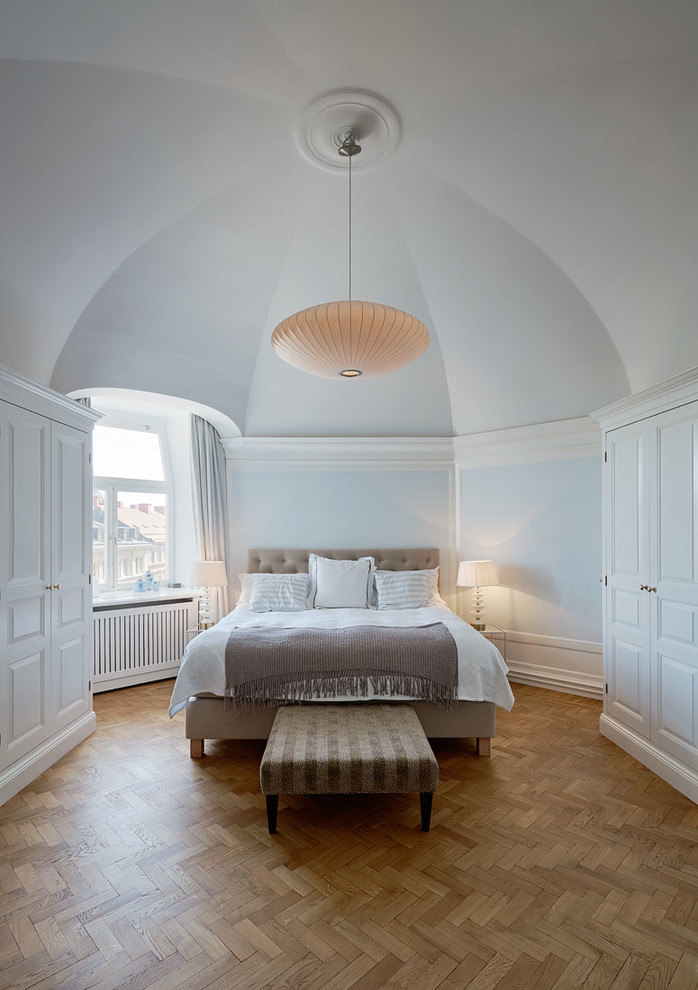 Design ideas for a large traditional master bedroom in Stockholm with blue walls and medium hardwood floors.