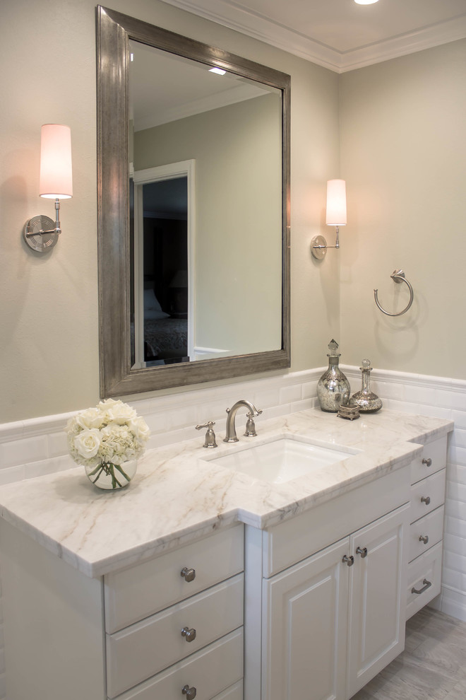 Inspiration for a mid-sized traditional 3/4 bathroom in Houston with raised-panel cabinets, white cabinets, white tile, subway tile, grey walls, porcelain floors, an undermount sink, quartzite benchtops, an alcove shower and a two-piece toilet.