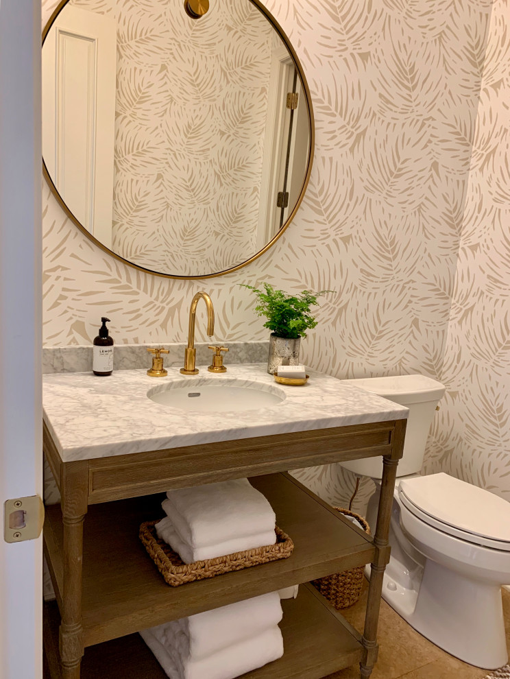 This is an example of a mid-sized transitional 3/4 bathroom in Milwaukee with furniture-like cabinets, distressed cabinets, a two-piece toilet, beige walls, cork floors, an undermount sink, marble benchtops, brown floor and white benchtops.