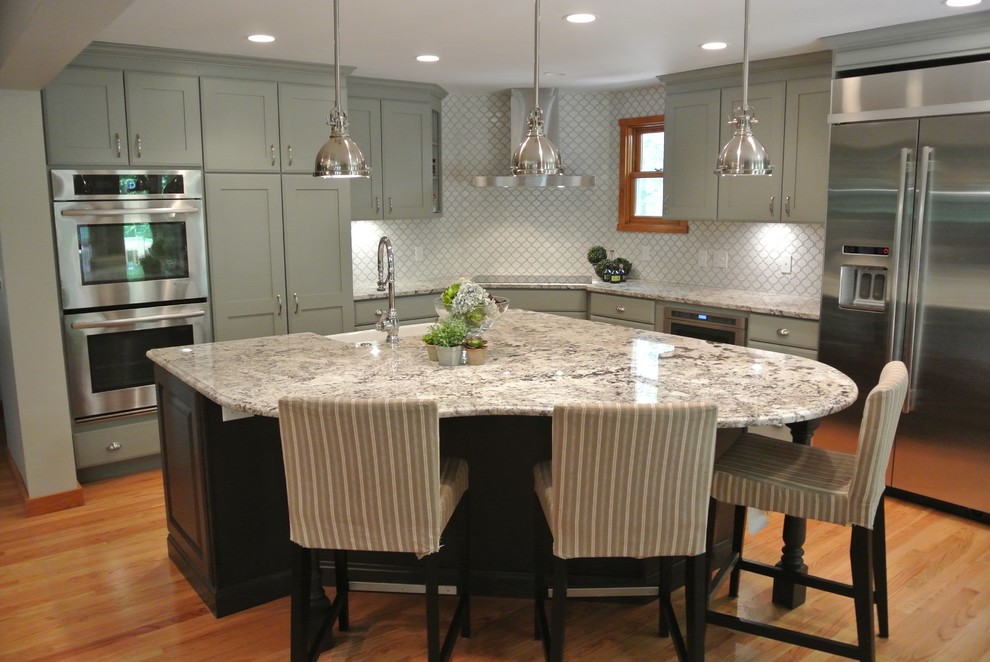 Eat-in kitchen - large transitional l-shaped light wood floor eat-in kitchen idea in Boston with a farmhouse sink, shaker cabinets, gray cabinets, granite countertops, white backsplash, ceramic backsplash, stainless steel appliances, an island and gray countertops
