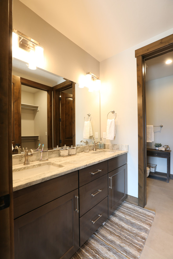 Large country master bathroom in Denver with flat-panel cabinets, brown cabinets, a drop-in tub, an alcove shower, a two-piece toilet, brown tile, stone tile, white walls, mosaic tile floors, an undermount sink, granite benchtops, brown floor, a hinged shower door and white benchtops.