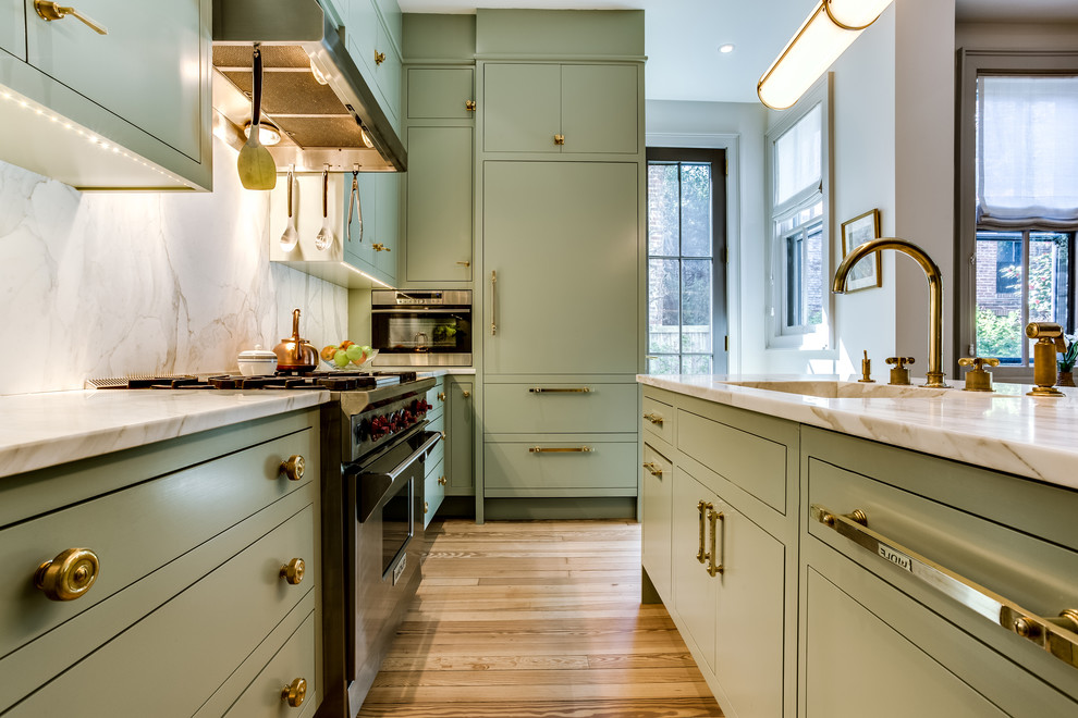 Design ideas for a mid-sized transitional l-shaped kitchen in DC Metro with an integrated sink, flat-panel cabinets, green cabinets, quartzite benchtops, stainless steel appliances, light hardwood floors, with island and brown floor.