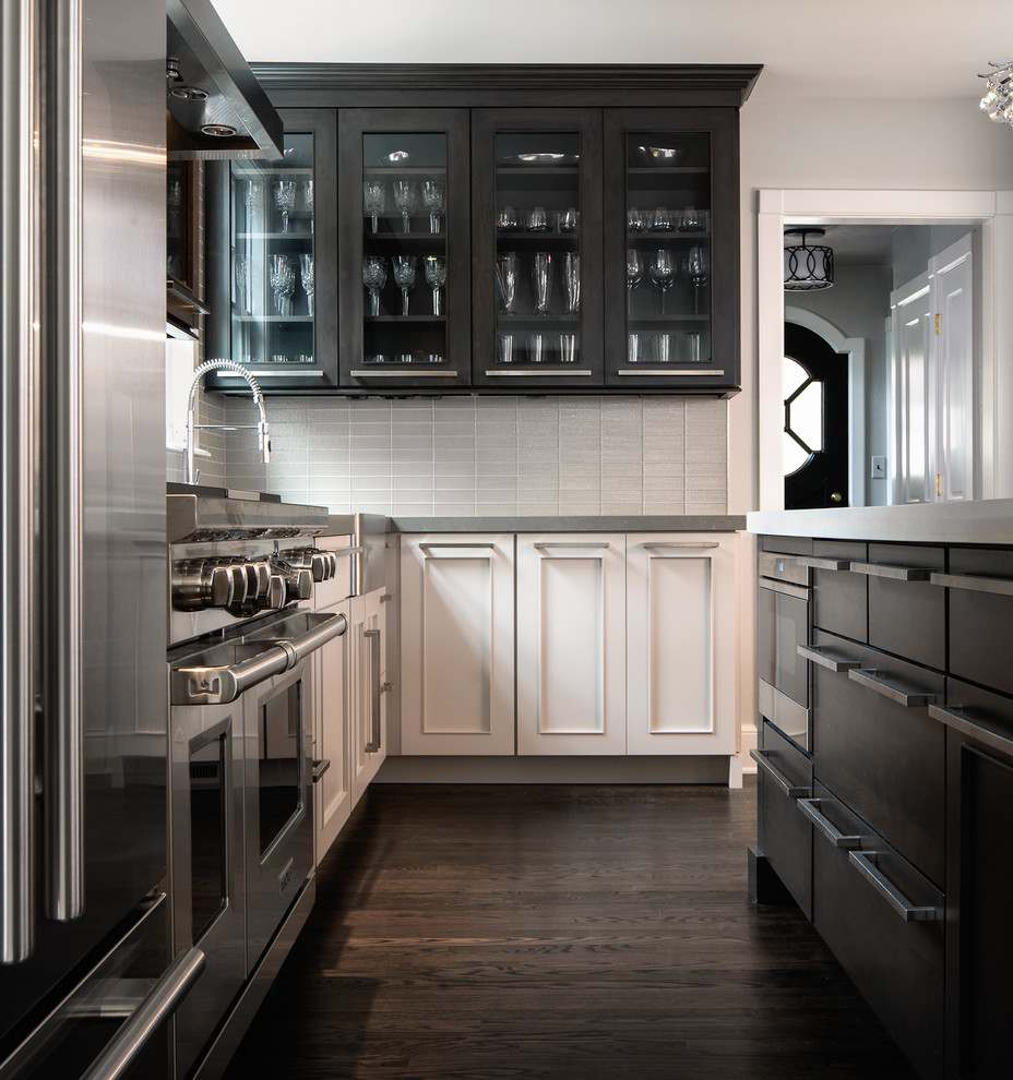 Mid-sized contemporary l-shaped eat-in kitchen in Birmingham with grey splashback, glass tile splashback, stainless steel appliances, dark hardwood floors, with island, quartz benchtops, flat-panel cabinets, dark wood cabinets, brown floor, grey benchtop and a farmhouse sink.