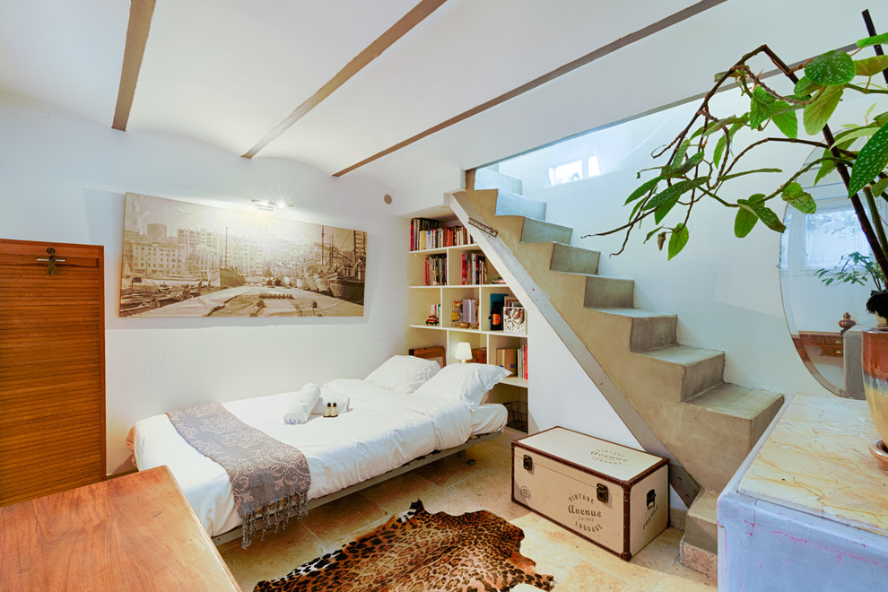 Mediterranean guest bedroom in Marseille with travertine floors, beige floor and white walls.