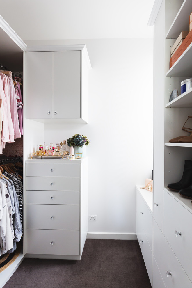 Photo of a mid-sized transitional women's walk-in wardrobe in Melbourne with flat-panel cabinets, white cabinets, carpet and grey floor.
