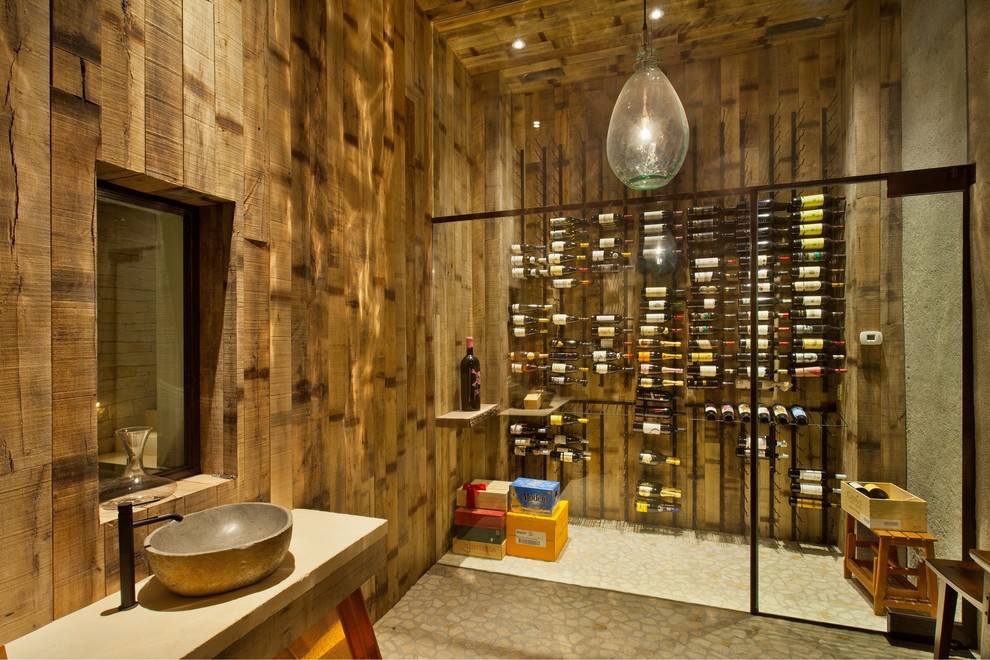 Photo of a mid-sized industrial wine cellar in Orange County with storage racks.