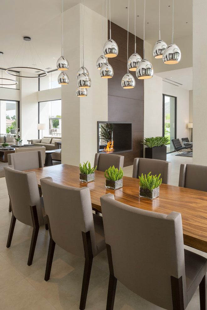 Design ideas for an expansive modern dining room in Phoenix with white walls, travertine flooring, a two-sided fireplace, a metal fireplace surround and white floors.