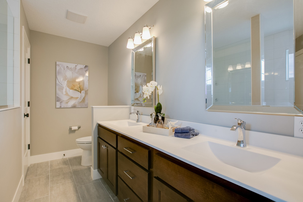 Photo of a mid-sized transitional master bathroom in Minneapolis with flat-panel cabinets, dark wood cabinets, an alcove shower, a two-piece toilet, white tile, ceramic tile, grey walls, ceramic floors, an integrated sink, solid surface benchtops, beige floor and an open shower.