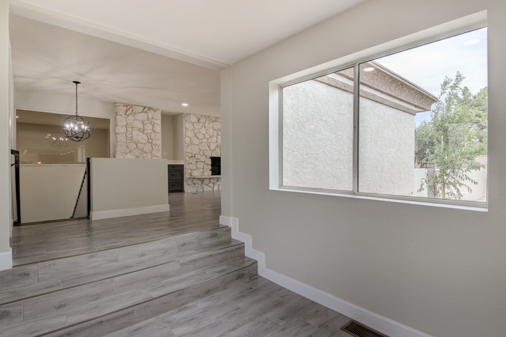 Front door - mid-sized transitional porcelain tile and gray floor front door idea in Phoenix with gray walls and a white front door