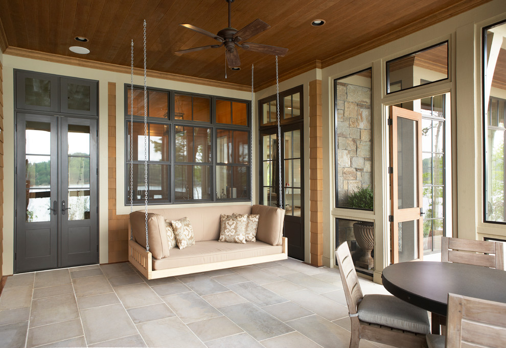 Photo of an expansive traditional backyard verandah in Other with natural stone pavers and a roof extension.