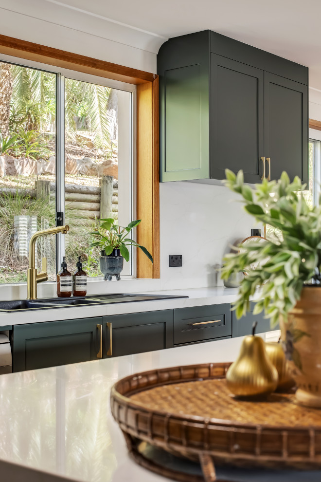 Eat-in kitchen - large transitional l-shaped medium tone wood floor and multicolored floor eat-in kitchen idea in Sydney with a drop-in sink, shaker cabinets, green cabinets, quartz countertops, white backsplash, quartz backsplash, black appliances, an island and white countertops