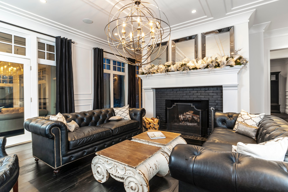 Photo of a transitional living room in Edmonton with white walls, dark hardwood floors, a standard fireplace, a brick fireplace surround and no tv.