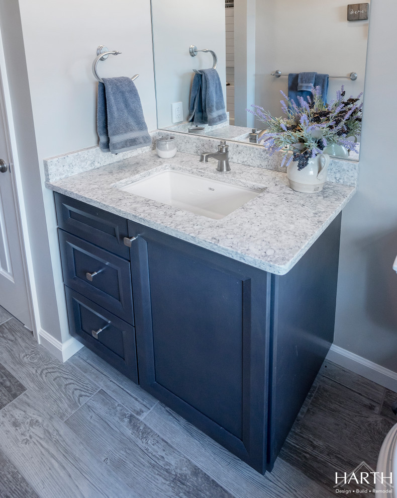 Mid-sized transitional 3/4 bathroom in Philadelphia with shaker cabinets, grey cabinets, an alcove tub, a shower/bathtub combo, a two-piece toilet, white tile, subway tile, grey walls, an undermount sink, engineered quartz benchtops, a shower curtain, grey benchtops, grey floor and wood-look tile.