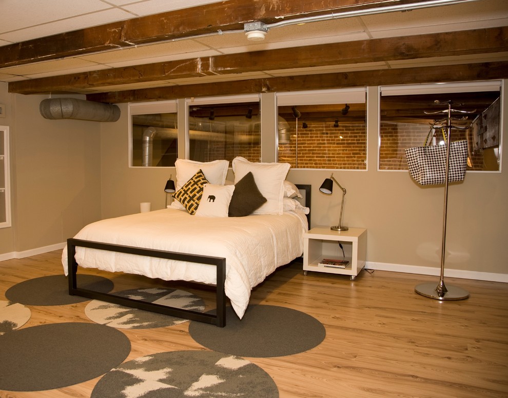 Design ideas for a mid-sized modern loft-style bedroom in Denver with beige walls, light hardwood floors and no fireplace.