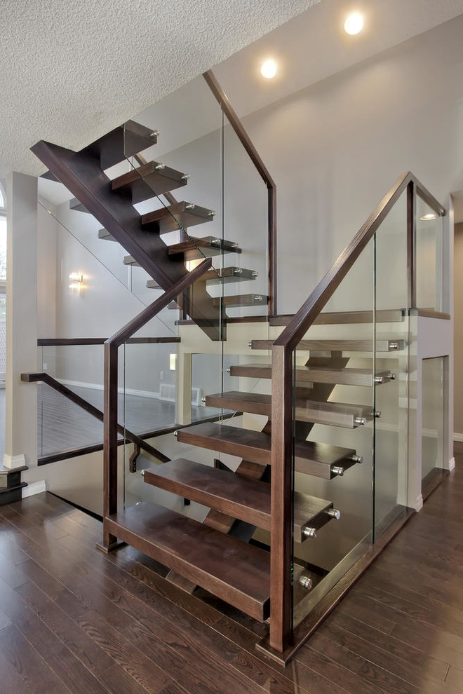 Large minimalist wooden floating glass railing staircase photo in Edmonton