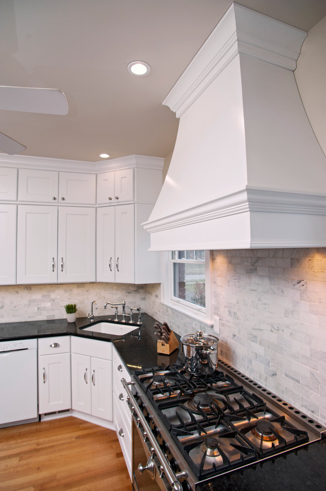 Photo of a small transitional u-shaped eat-in kitchen in Other with an undermount sink, recessed-panel cabinets, white cabinets, granite benchtops, grey splashback, stone tile splashback, white appliances and medium hardwood floors.