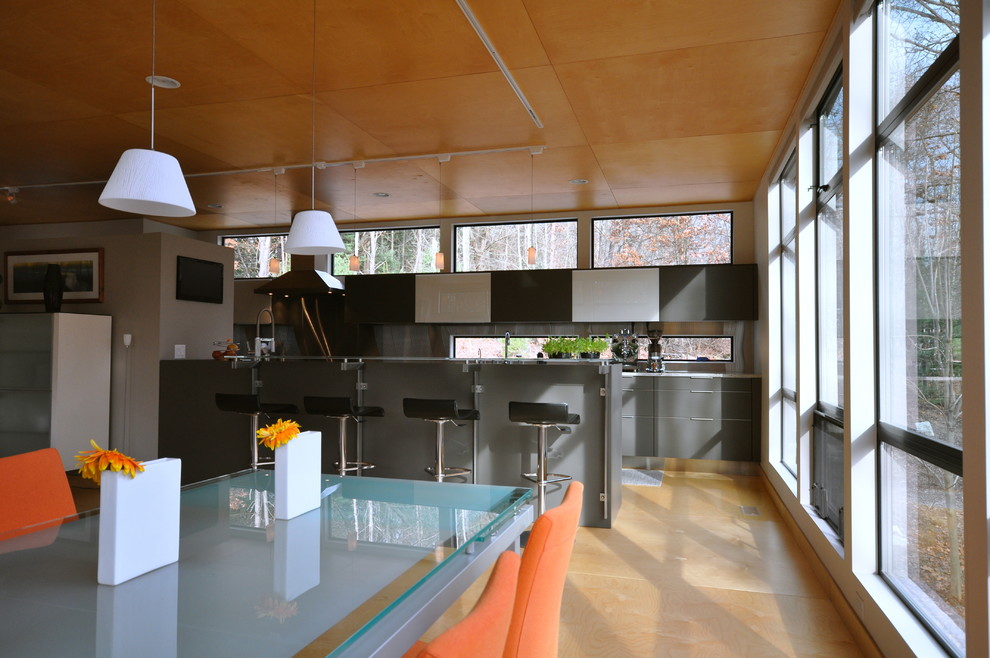 This is an example of a contemporary galley eat-in kitchen in Grand Rapids with an undermount sink, glass-front cabinets, grey cabinets, granite benchtops and stainless steel appliances.