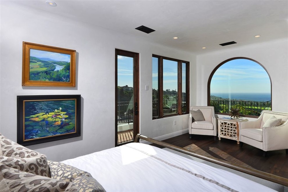 Photo of a large contemporary master bedroom in San Diego with white walls and brown floor.