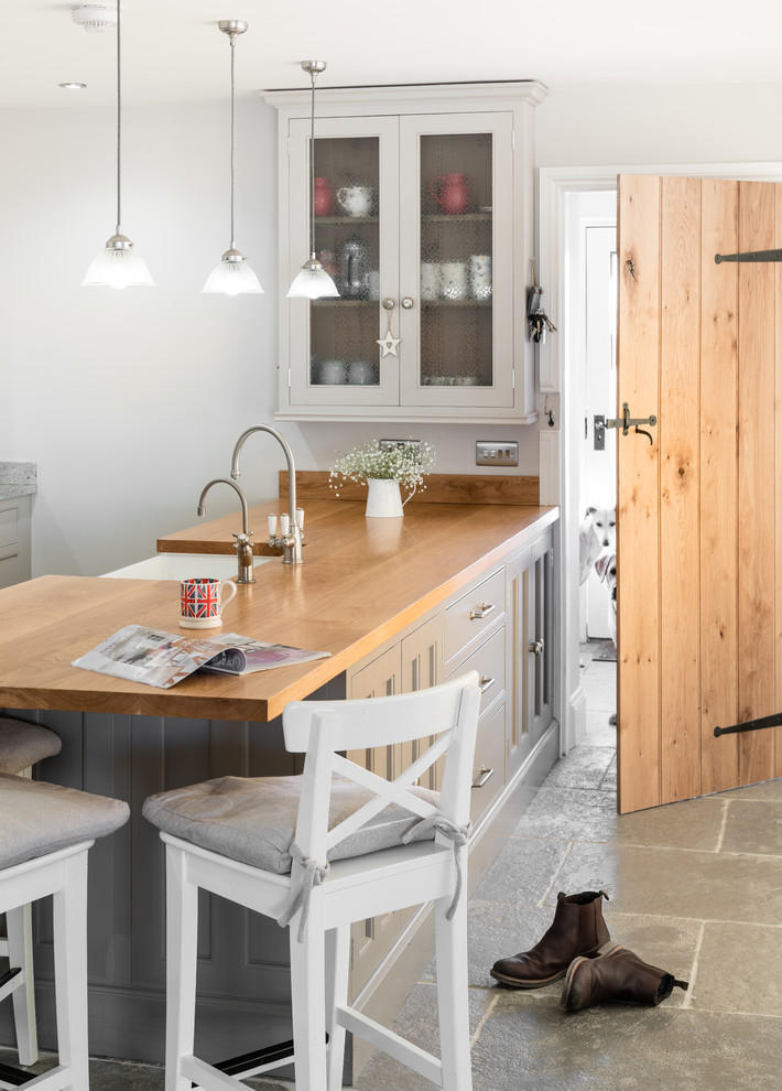 Design ideas for a mid-sized country eat-in kitchen in Cambridgeshire with grey cabinets and with island.