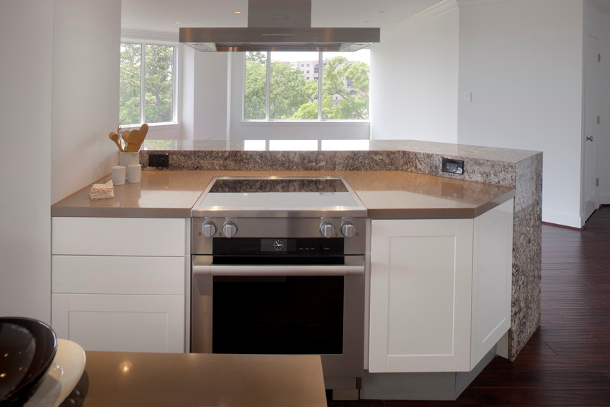 Inspiration for a mid-sized modern galley medium tone wood floor eat-in kitchen remodel in Houston with an undermount sink, flat-panel cabinets, white cabinets, solid surface countertops, brown backsplash, stone slab backsplash, stainless steel appliances and an island