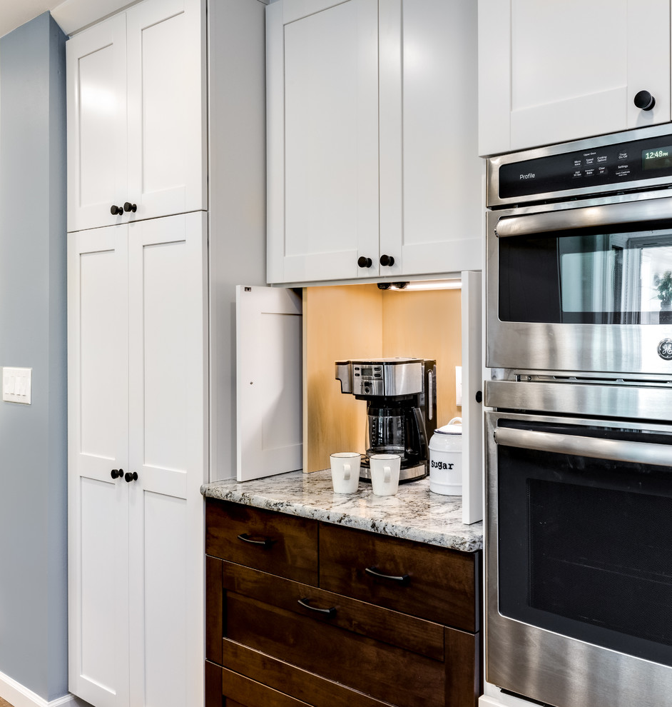Eat-in kitchen - mid-sized transitional galley medium tone wood floor and brown floor eat-in kitchen idea in Denver with an undermount sink, shaker cabinets, white cabinets, granite countertops, blue backsplash, glass tile backsplash, stainless steel appliances, an island and beige countertops