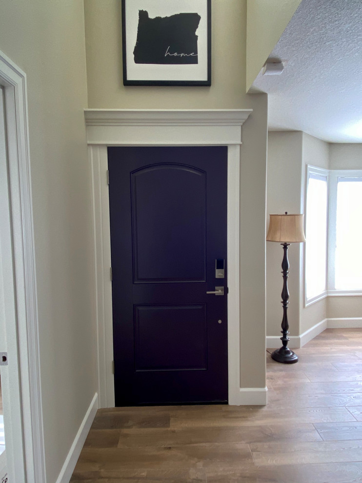 Exemple d'une petite porte d'entrée chic avec un mur beige, un sol en bois brun, une porte simple, une porte violette, un sol marron et un plafond voûté.
