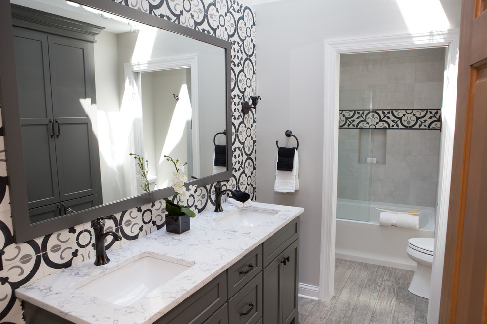 Bathroom - mid-sized transitional 3/4 multicolored tile and ceramic tile porcelain tile and multicolored floor bathroom idea in Chicago with recessed-panel cabinets, gray cabinets, a two-piece toilet, gray walls, an undermount sink, quartz countertops and a hinged shower door