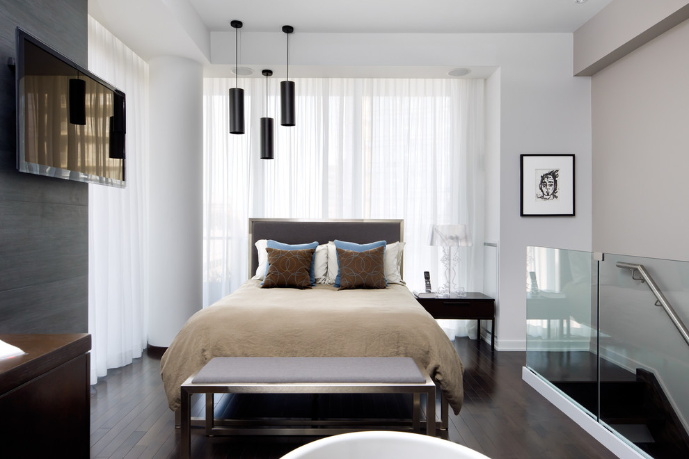 Design ideas for a contemporary loft-style bedroom in Toronto with beige walls and dark hardwood floors.