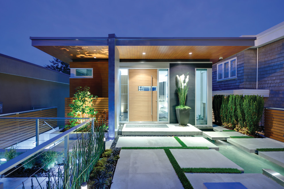 This is an example of a contemporary entryway in Vancouver with a pivot front door and a medium wood front door.