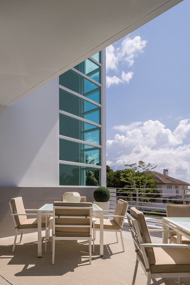 Design ideas for a large contemporary rooftop deck in Miami with a roof extension.