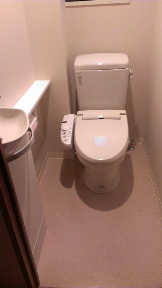 Large arts and crafts powder room in Tokyo with flat-panel cabinets, white cabinets, a two-piece toilet, white walls, linoleum floors, a wall-mount sink and wood benchtops.