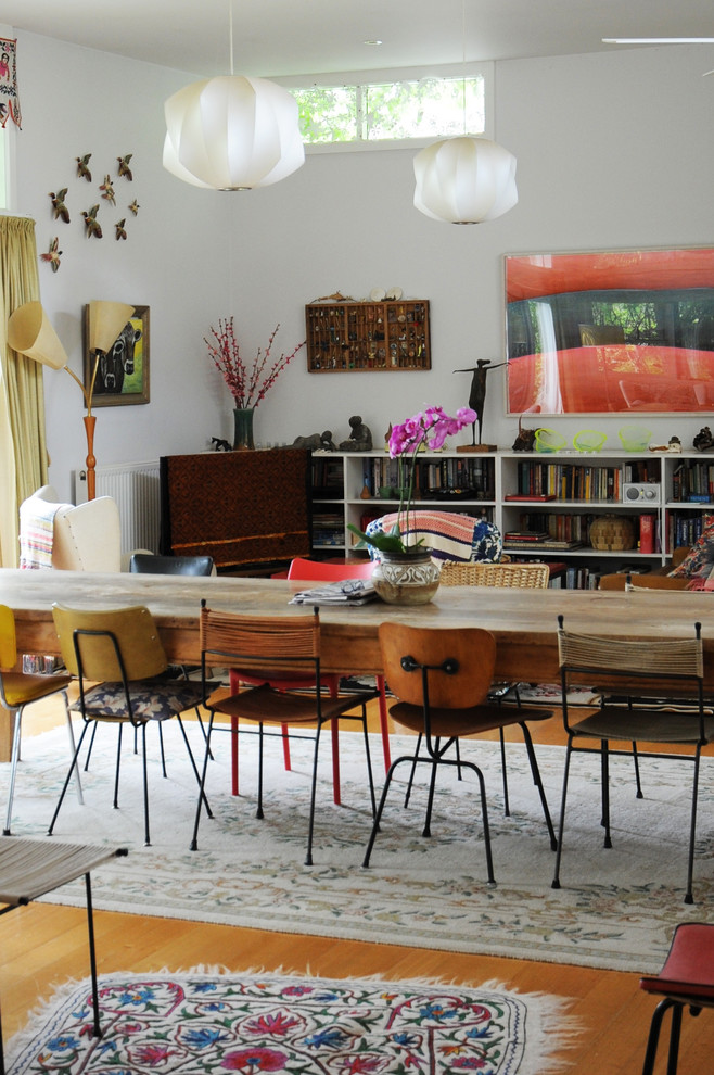 Eclectic dining room in Sydney with white walls and medium hardwood floors.
