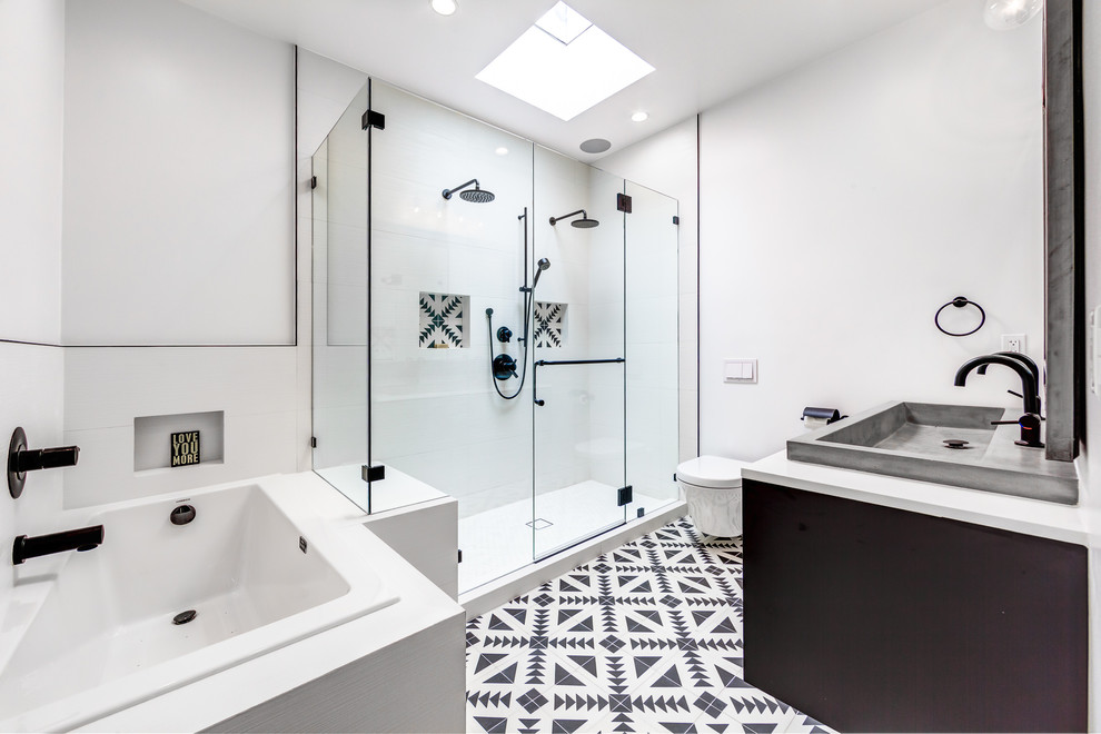 This is an example of a contemporary master bathroom in San Francisco with a drop-in tub, a double shower, a wall-mount toilet, white walls, an integrated sink, white floor, a hinged shower door and white benchtops.