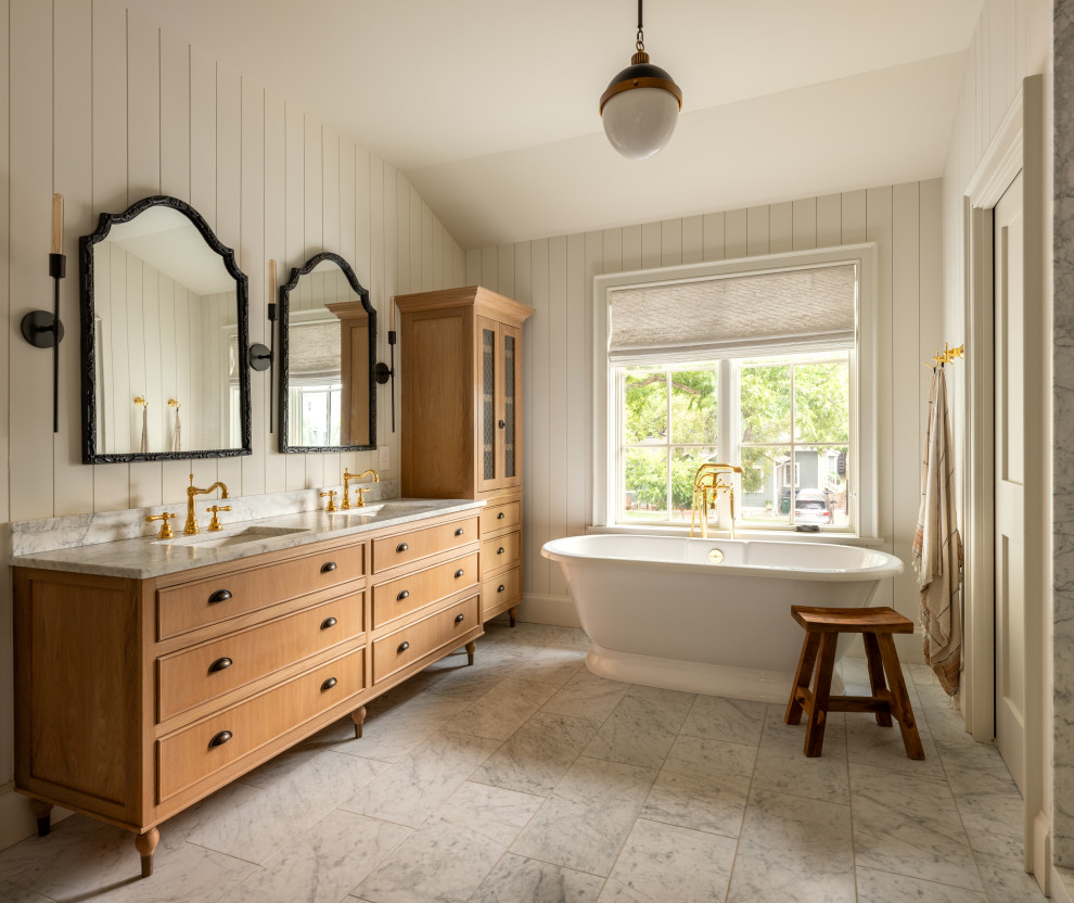 Ramsey House - Freestanding bathtub - country gray floor, double-sink and shiplap wall freestanding bathtub idea in Austin with recessed-panel cabinets, medium tone wood cabinets, white walls, an undermount sink, white countertops and a freestanding vanity