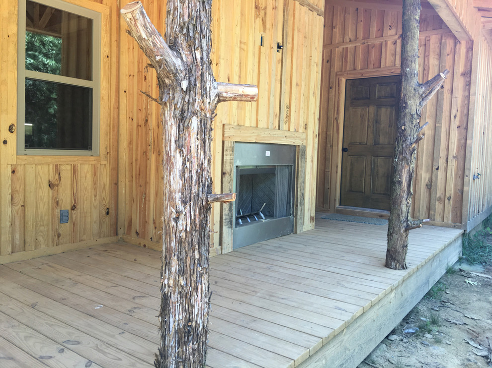 Inspiration for a large rustic front porch remodel with decking and a roof extension
