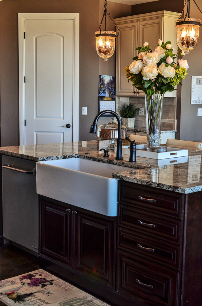 Open concept kitchen - mid-sized transitional l-shaped dark wood floor and brown floor open concept kitchen idea in Denver with a farmhouse sink, raised-panel cabinets, white cabinets, granite countertops, gray backsplash, porcelain backsplash, stainless steel appliances, an island and gray countertops