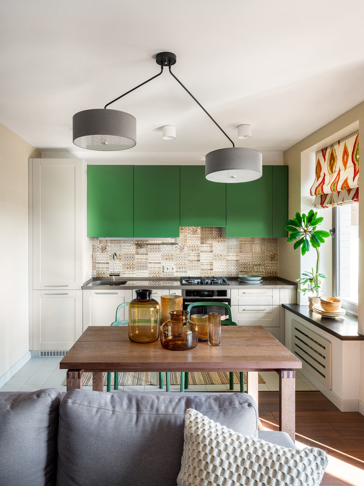 Photo of a mid-sized eclectic single-wall open plan kitchen in Moscow with an integrated sink, flat-panel cabinets, green cabinets, quartz benchtops, ceramic splashback, ceramic floors, no island, white floor, beige splashback, stainless steel appliances and grey benchtop.