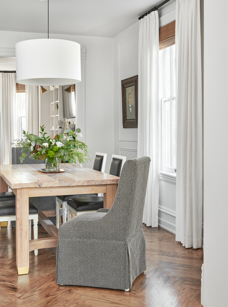 Design ideas for a transitional separate dining room in Toronto with white walls, medium hardwood floors, brown floor and panelled walls.