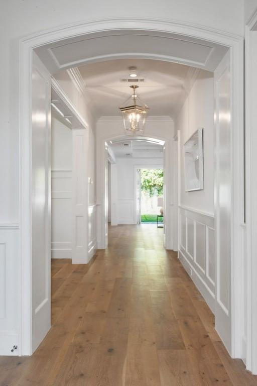 Aménagement d'un couloir craftsman avec un mur blanc, un sol en bois brun, un sol beige, un plafond en bois et du lambris.