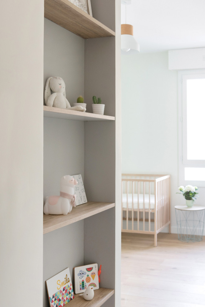 Exemple d'une chambre de bébé neutre tendance de taille moyenne avec un mur gris et parquet clair.