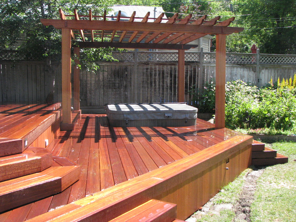 Traditional backyard deck in Calgary with a pergola.