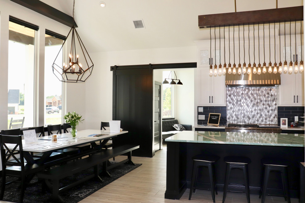 Large modern galley open plan kitchen in Oklahoma City with shaker cabinets, black splashback, ceramic floors and with island.