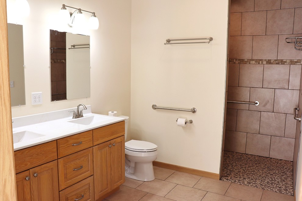 This is an example of a mid-sized traditional master bathroom in Cedar Rapids with raised-panel cabinets, a curbless shower, porcelain floors, an integrated sink and an open shower.