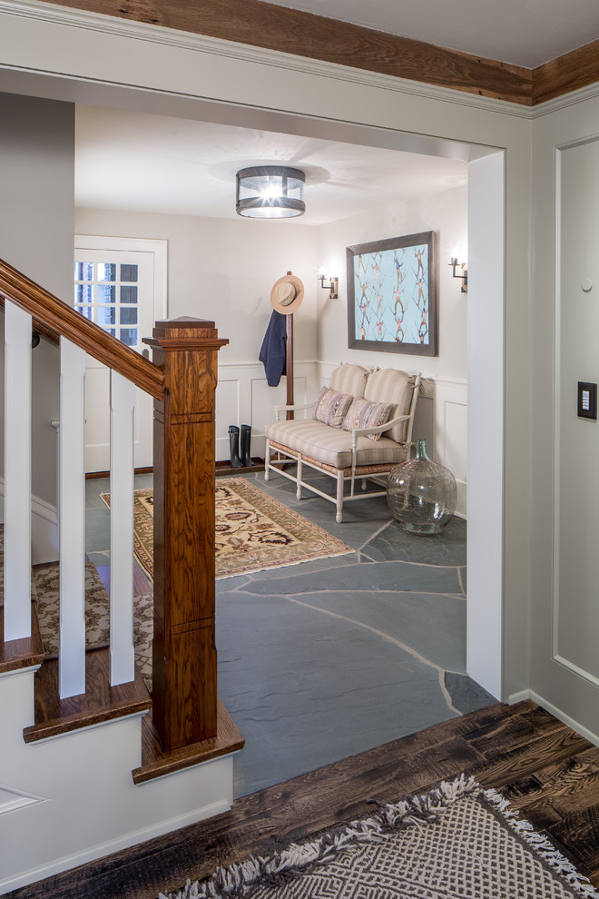 This is an example of a large traditional foyer in Minneapolis with grey walls, slate floors, a single front door and a white front door.