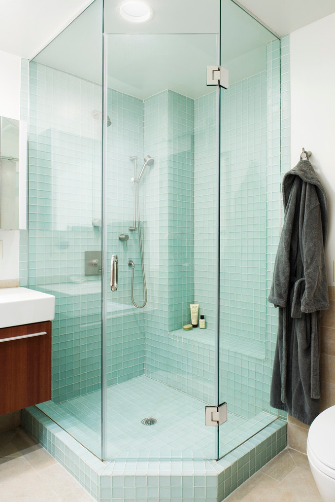 Design ideas for a mid-sized eclectic master bathroom in New York with a corner shower, blue tile, flat-panel cabinets, dark wood cabinets, a drop-in tub, glass tile, white walls, ceramic floors, a wall-mount sink and solid surface benchtops.